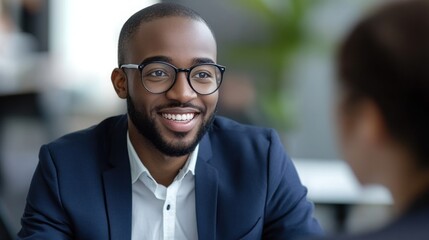 Fototapeta premium Confident Black businessman smiles during a professional meeting, showcasing success and positive communication.