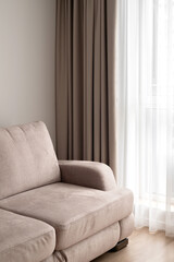 Minimal neutral modern design interior, soft velure taupe beige sofa, linen curtains on window with...