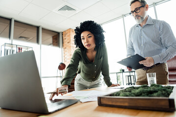 Focused professionals discussing a project in a modern office environment, showcasing teamwork and...