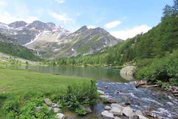L'incantevole lago di Arpy in Valle d'Aosta, circondato dal verde e dalle montagne.