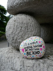 Old stone statue ball with be kind kindness rock vertical photo