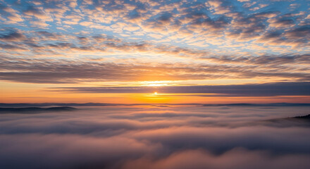 Fototapeta premium Majestic sunrise painting the sky with cosmic colors of orange and blue above a surreal and ethereal ocean of clouds