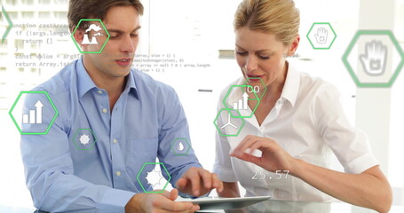 Collaborating colleagues in button-down shirts analyzing data on tablet at office with data icons
