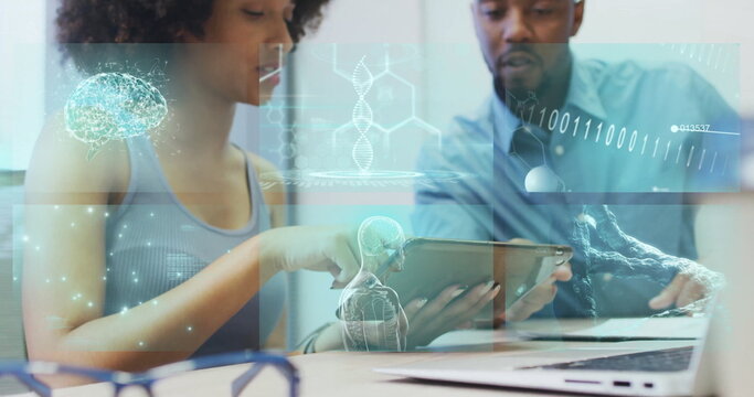 Two researchers collaborating, examining medical holograms on tablet at lab, laptop and eyeglasses