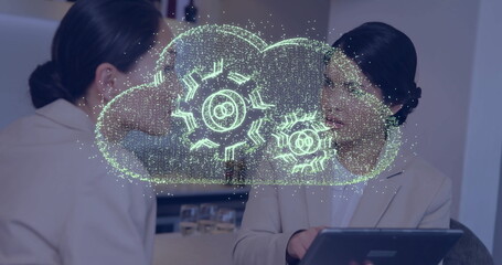 Two professionals discussing technology with cloud and gears image overlay