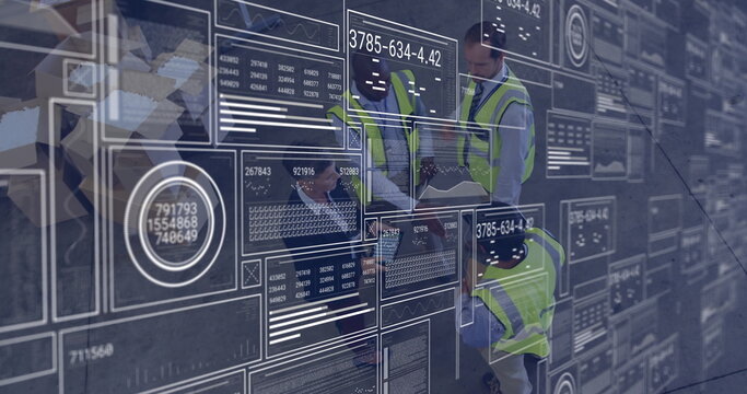 Analyzing digital data interfaces and graphs, engineers in safety vests working