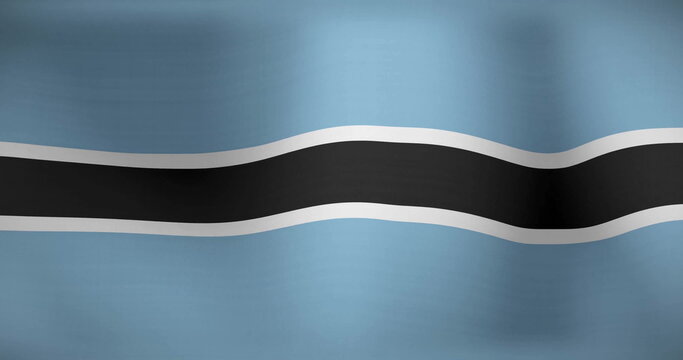Rippling Botswana national flag gently in close-up view, with central black stripe edged in white