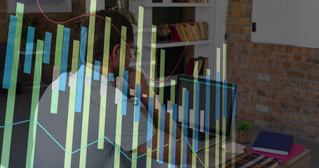 Working on laptop, businessman analyzing financial graph image in office