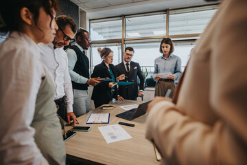A multicultural group of business people actively participating in a meeting around a table,...