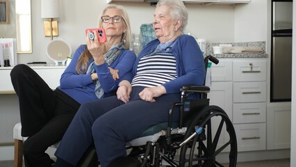 A daughter and her elderly mother enjoy a warm video chat at home, capturing precious memories and...