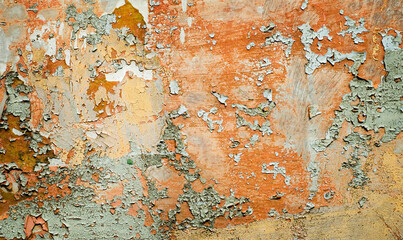 Old surface with peeling paint and rust. Vintage background with crackles and peeling paint of yellow, brown, gray, orange and blue colors.