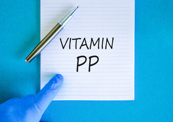 Vitamin PP symbol. Concept words Vitamin PP on beautiful white note. Doctor's hand in blue medical...