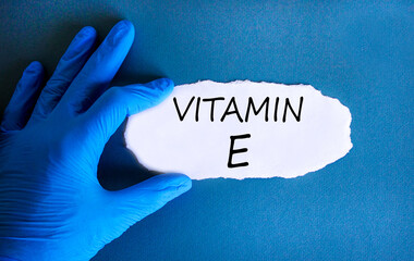 Vitamin E tocopherols symbol. Concept words Vitamin E on beautiful white paper. Doctor's hand in...