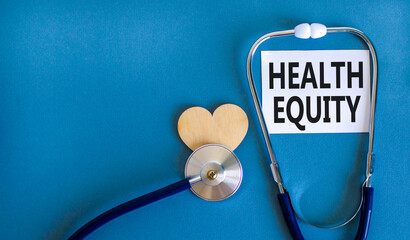Health equity symbol. Concept words Health equity on beautiful white card. Wooden heart and...