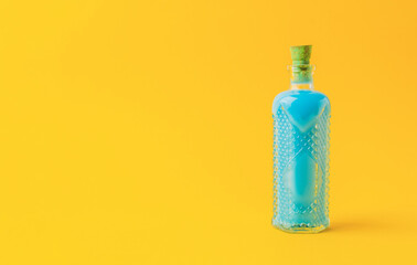 Bottle of blue liquid is sitting on a yellow background