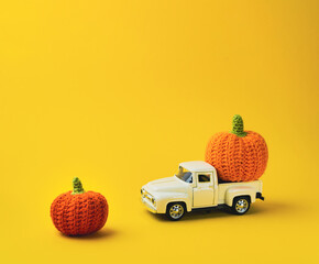 White truck is carrying two orange pumpkins