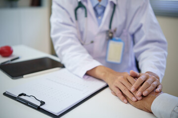 Hands of doctor comforting older person, symbolizing trust and patient care. Health care concept.