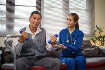 Home care nurse guiding an elderly patient through physical therapy on a sofa.