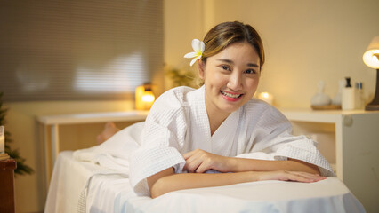 Smiling woman lying on massage bed,  ready for a relaxing massage session.