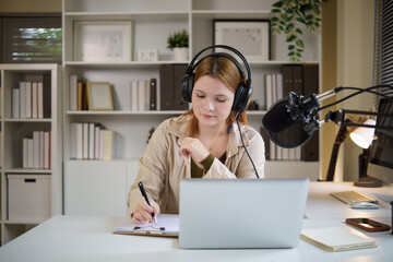 Podcast host  taking notes while recording a podcast at home with professional microphone.