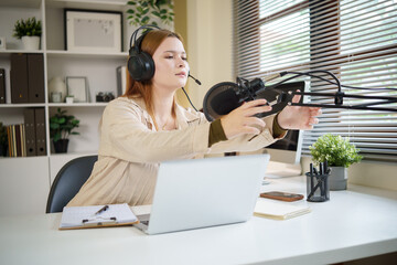 Smiling woman preparing podcast equipment for live session or interview.