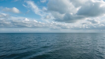 Fototapeta premium Vast ocean under a partly cloudy sky, with gentle waves and open horizon. Nature and seascape, calm and peaceful, maritime scene.