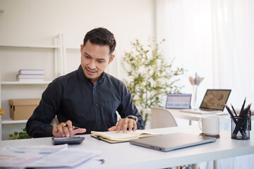 Focused accountant analyzing business reports and calculating financial data.