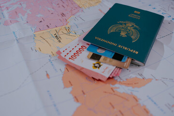 Passports and rupiahs, indonesian and credit card on a map background. Travel concept.