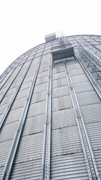 Big storage elevator construction. Steel hude agricultural storage for farming. Vertical video