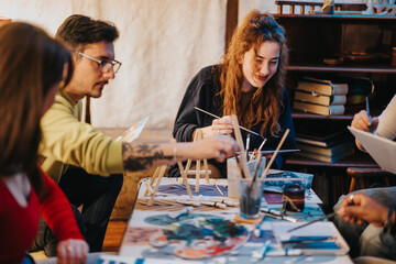 Fototapeta premium People participating in an artistic activity, sharing ideas, and creating together in a cozy studio environment, promoting teamwork, creativity, and engagement in their collective artistic exploration