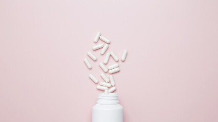 Concept of healthcare and medicine. White bottle container with medication capsules