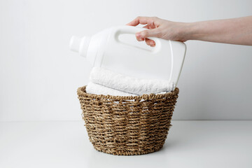 Laundry detergent branding mock up and basket filled with clean white towels. Household cleaning...