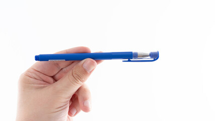 Hand holding a blue pen against a white background showing focus on writing tools