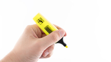 Hand holding bright yellow highlighter against plain white background for emphasis and note-taking
