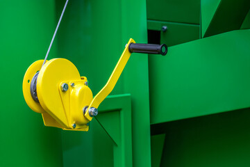 A yellow and black tool with a chain attached to it
