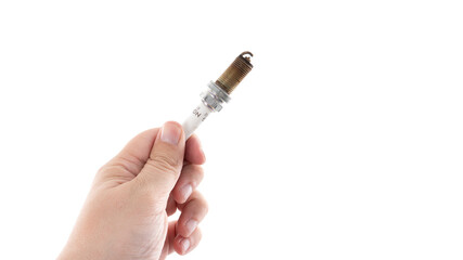 Hand holding a spark plug in a bright, neutral background showcasing automotive components and tools