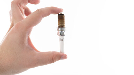 Detailed view of a hand holding a spark plug against a white background showcasing its design and...