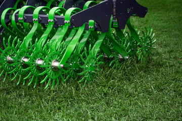 A green machine with green wheels is on a grassy field