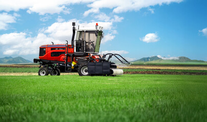 A red and white tractor is in a field of grass