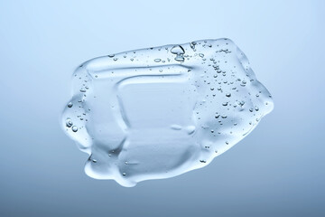 The texture of a cosmetic gel with bubbles on a blue background.
