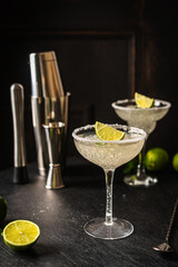Margarita cocktail with lime and ice on dark wooden table with copy space. Classic Margarita and...