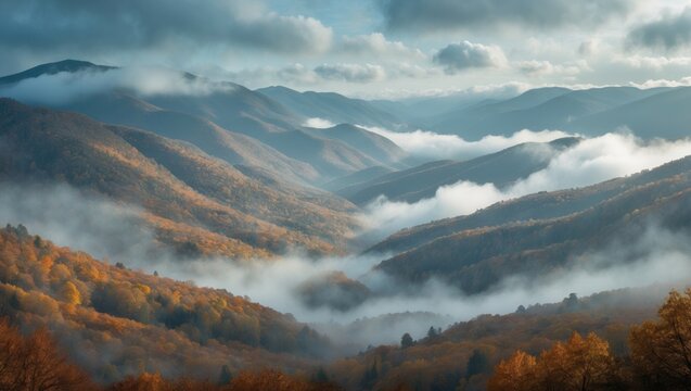 Autumn mountain landscape with fog and clouds over rolling hills and forests.