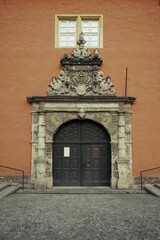 Close-up of an ornate Renaissance portal with intricate stone carvings and a dark wooden door, set...