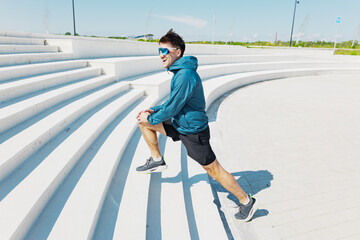 A passionate running enthusiast is seen executing lunges on sleek, modern white steps in a sunny...