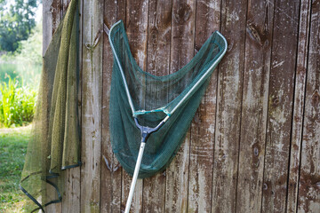 Fishing tools hanging on the wall of a fishing cabin next to a lake