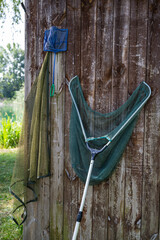 Fishing tools hanging on the wall of a fishing cabin next to a lake