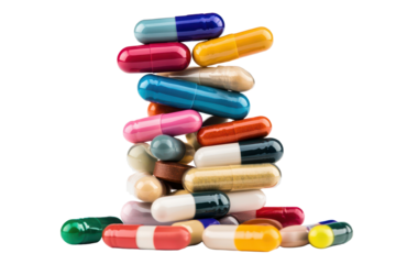 Colorful stack of pills and capsules balances precariously on a surface, showcasing a variety of shapes and colors in a striking arrangement