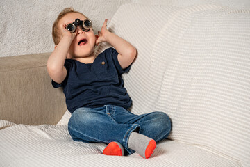 Toddler with tiny binoculars exploring his living room.
Amazed kid discovering his world more...