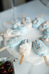 Colorful decorated ice cream pops on a white plate with cherries and elegant table setting