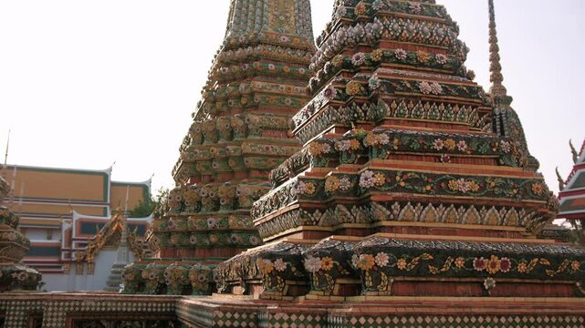 Ancient buddhist temple wat pho featuring ornamental architectural details, highlighting intricate stupa decorations and traditional roof design in Bangkok, Thailand.